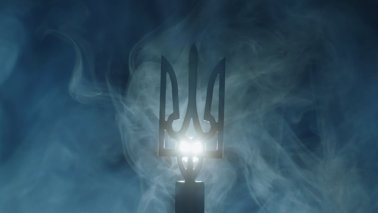 el escudo de armas de ucrania en la niebla, iluminado por un reflector