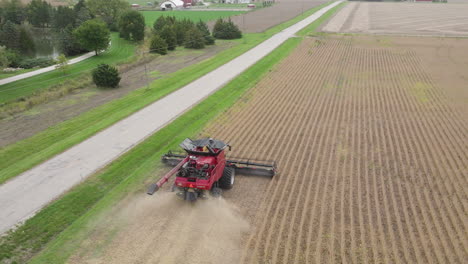 aerial, combine harvester harvesting grain crops on farm field