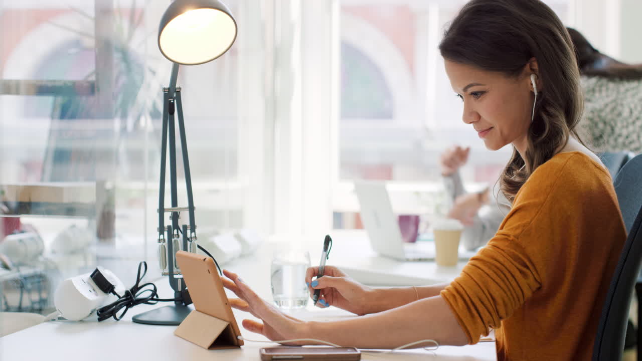 equipo de raza mixta de jóvenes empresarios que trabajan en oficinas de plan abierto filas de escritorio de computadoras en un espacio de trabajo compartido luz natural brillante