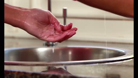 Woman-washing-her-hands-in-a-sink-