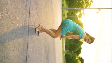 woman dancing in a teal dress at sunset