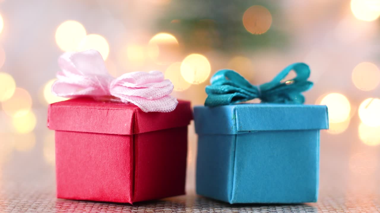 mini regalos de navidad rojos y azules con luces parpadeantes detrás