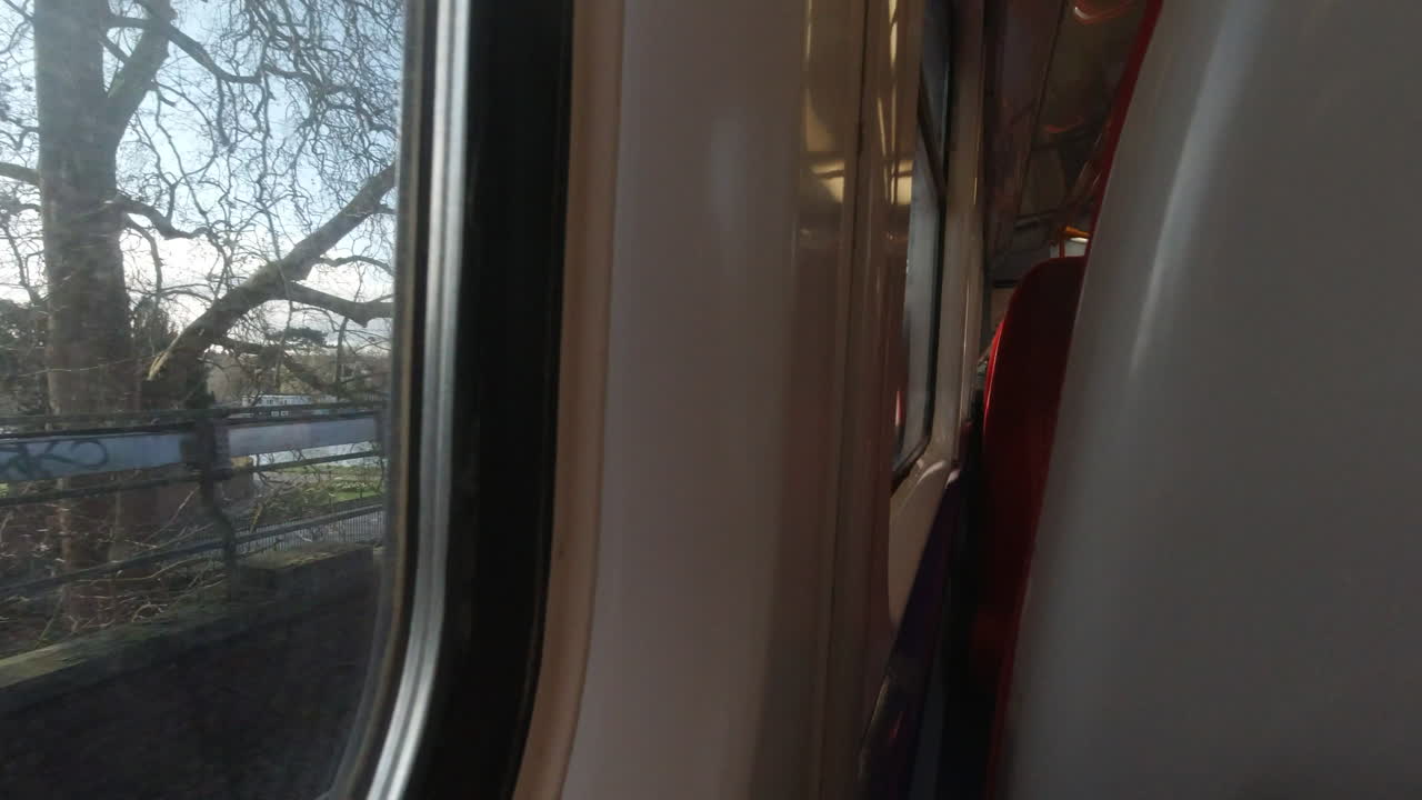 tomada en un tren en movimiento en el suroeste de londres. la toma incluye los asientos del tren y la ventana.