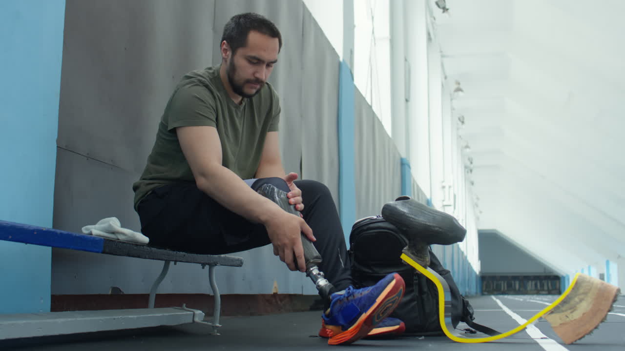 Athlete Putting on Prosthetic Leg before Workout