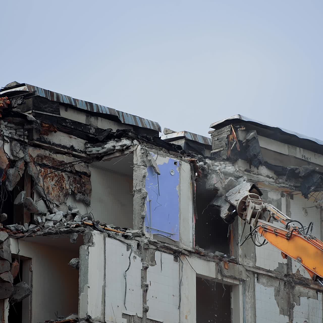 Dismantling the upper floors of the multi-storey building. Crushing the floors of the high house. Excavator work in the deconstruction site
