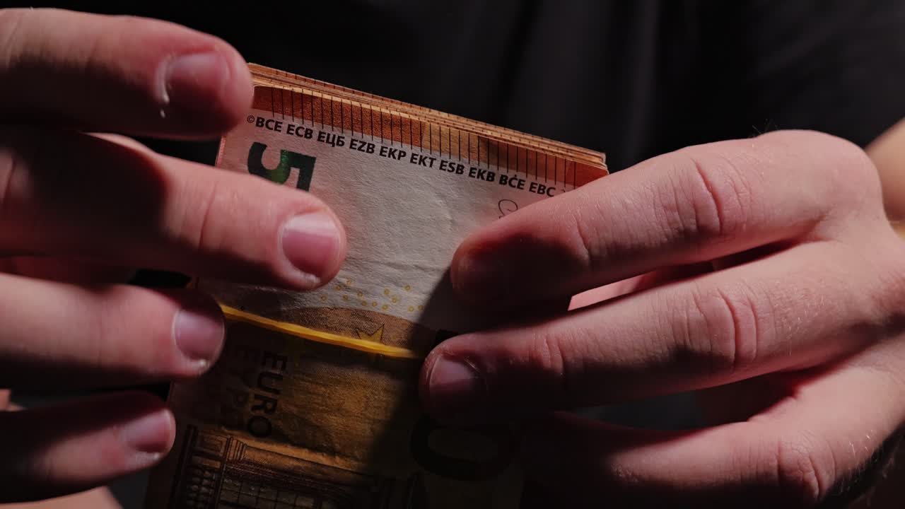 Euro Banknote Bundle Wrapped with Rubber Band in Male Hands, Crime Economy