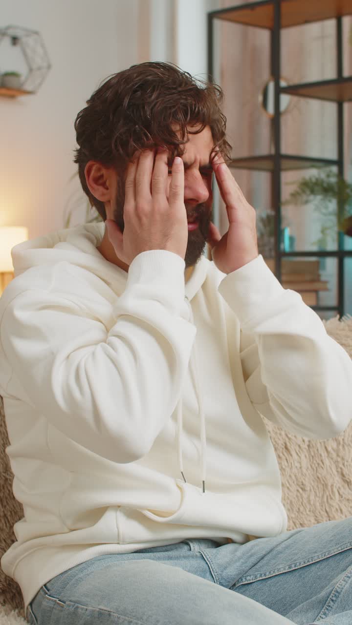 Displeased young man rubbing temple to cure headache problem suffering from tension and migraine