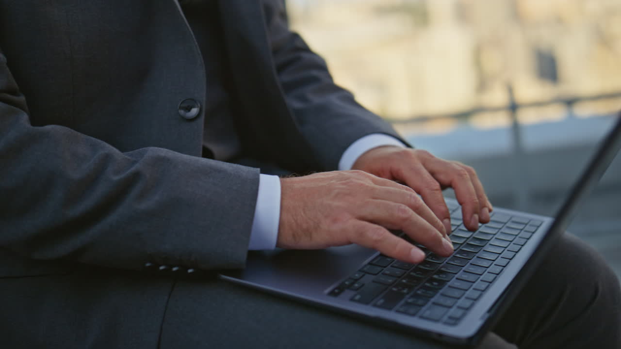 Manager hands typing keyboard closeup. Urban businessman in suit work laptop