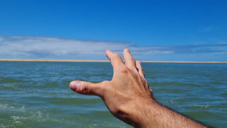 naila lagoon, western sahara: outstretched hand of a man enjoying the wind and nature