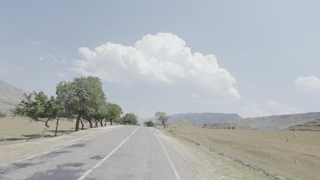 scenic mountain road with trees and clouds