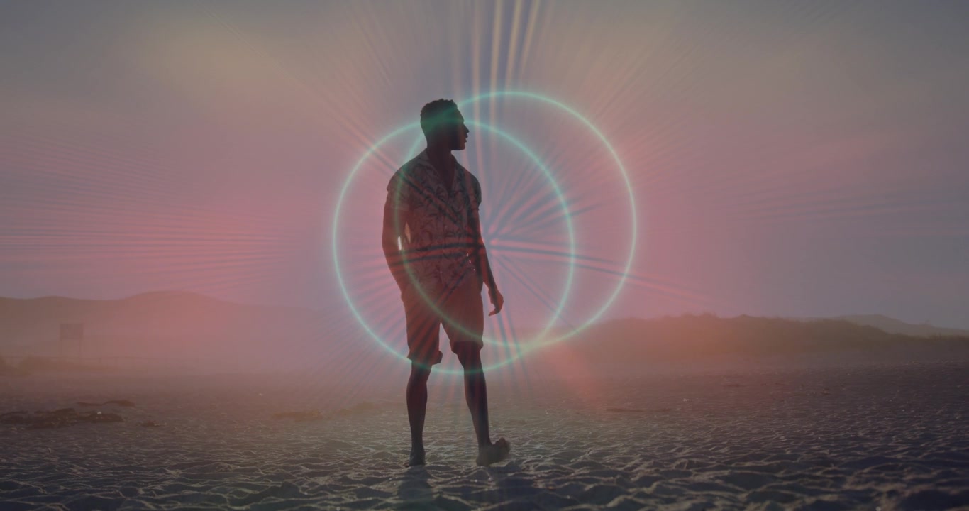 Man turning and inspecting on beach, luminous rings forming behind him, pulsing inviting tech study