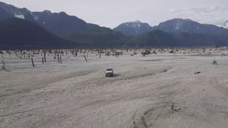 Drone-aerial-shot-of-two-jeeps-by-the-water-desert-in-No-Man's-Land-in-British-columbia