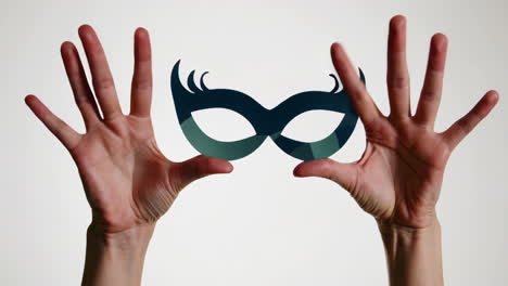 hands holding a decorative mask