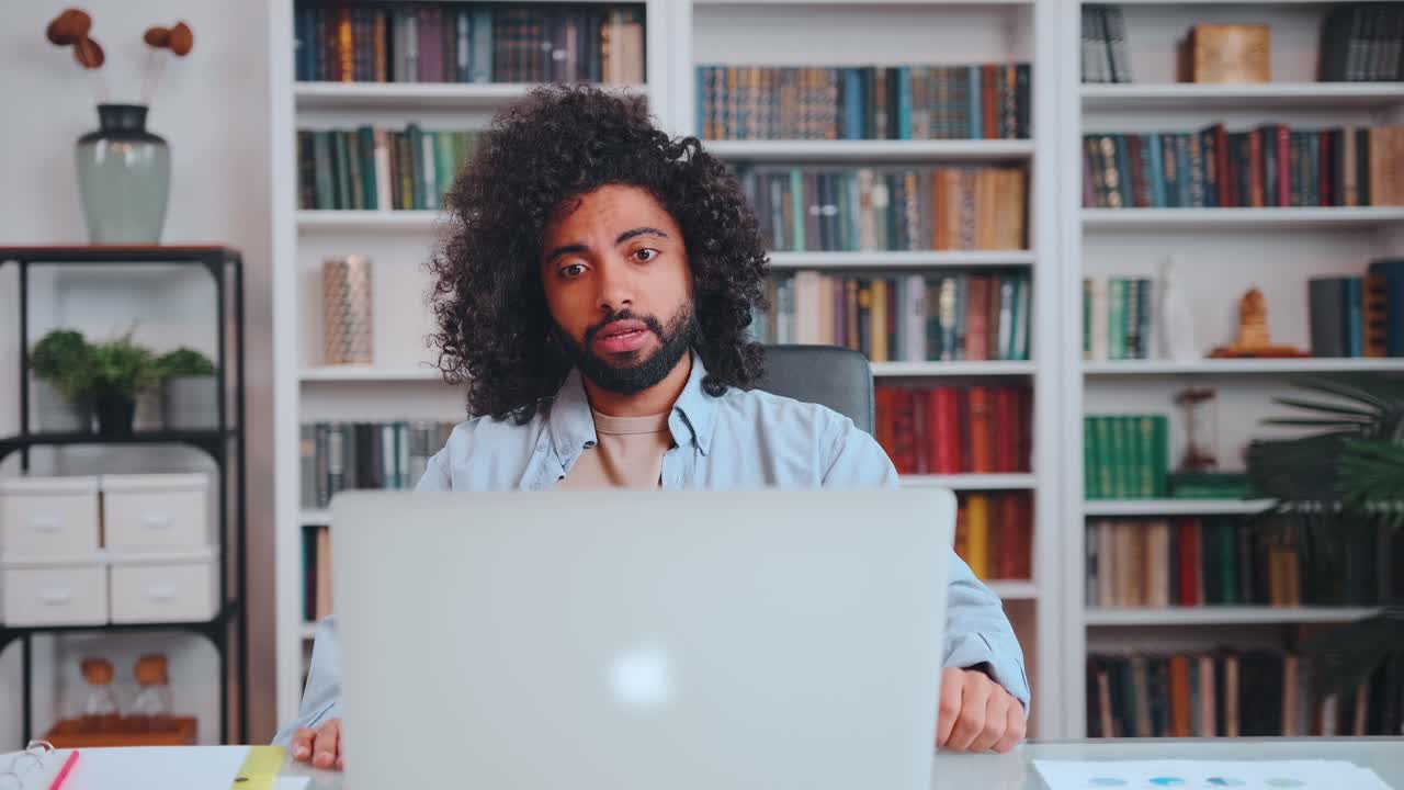 Young excitable arabian american man fan angry and screaming looking at laptop