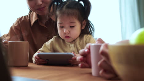 Asiatische-Frau-Sitzt-Mit-Ihrem-Baby-An-Einem-Tisch