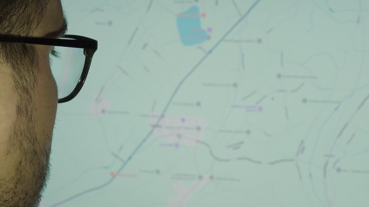 A man looks closely at an online map, analyzing and pointing at a location — concept of navigation, travel planning, and digital exploration