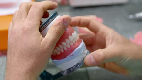 dental technician works in his workshop and makes artificial teeth for dentistry