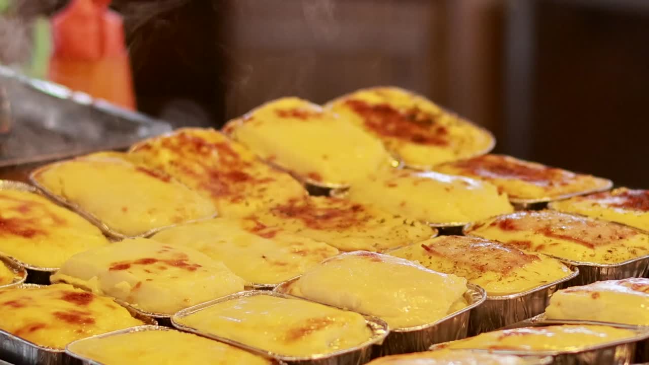 Close-up of steaming, golden-brown pastries grilling on a metal tray, showcasing their crispy texture and inviting aroma.