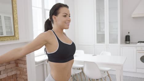 mujer joven estirando el cuerpo en casa