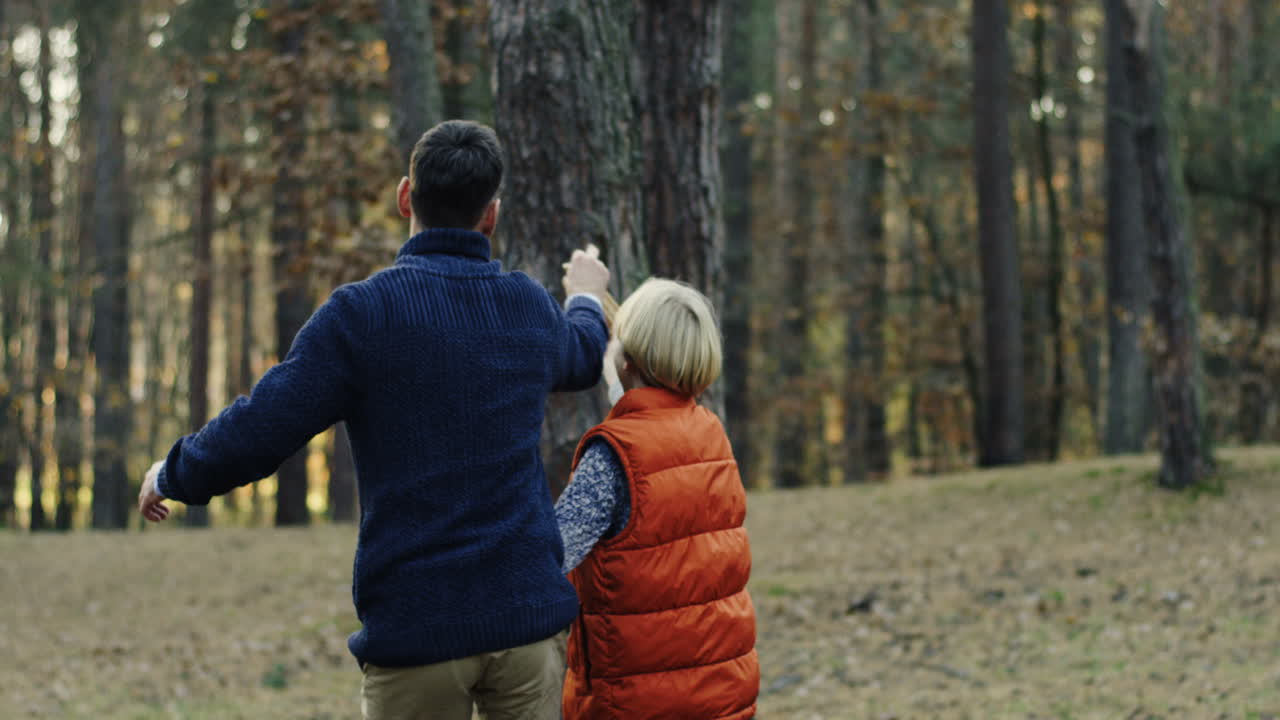 hombre guapo caucásico jugando con su pequeño hijo lindo con un avión de madera en el bosque