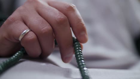 close up of practicing muslim's hand making tasbih using misbaha