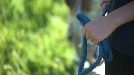 primer plano de una mujer sosteniendo un caballo mientras pasta en el fondo