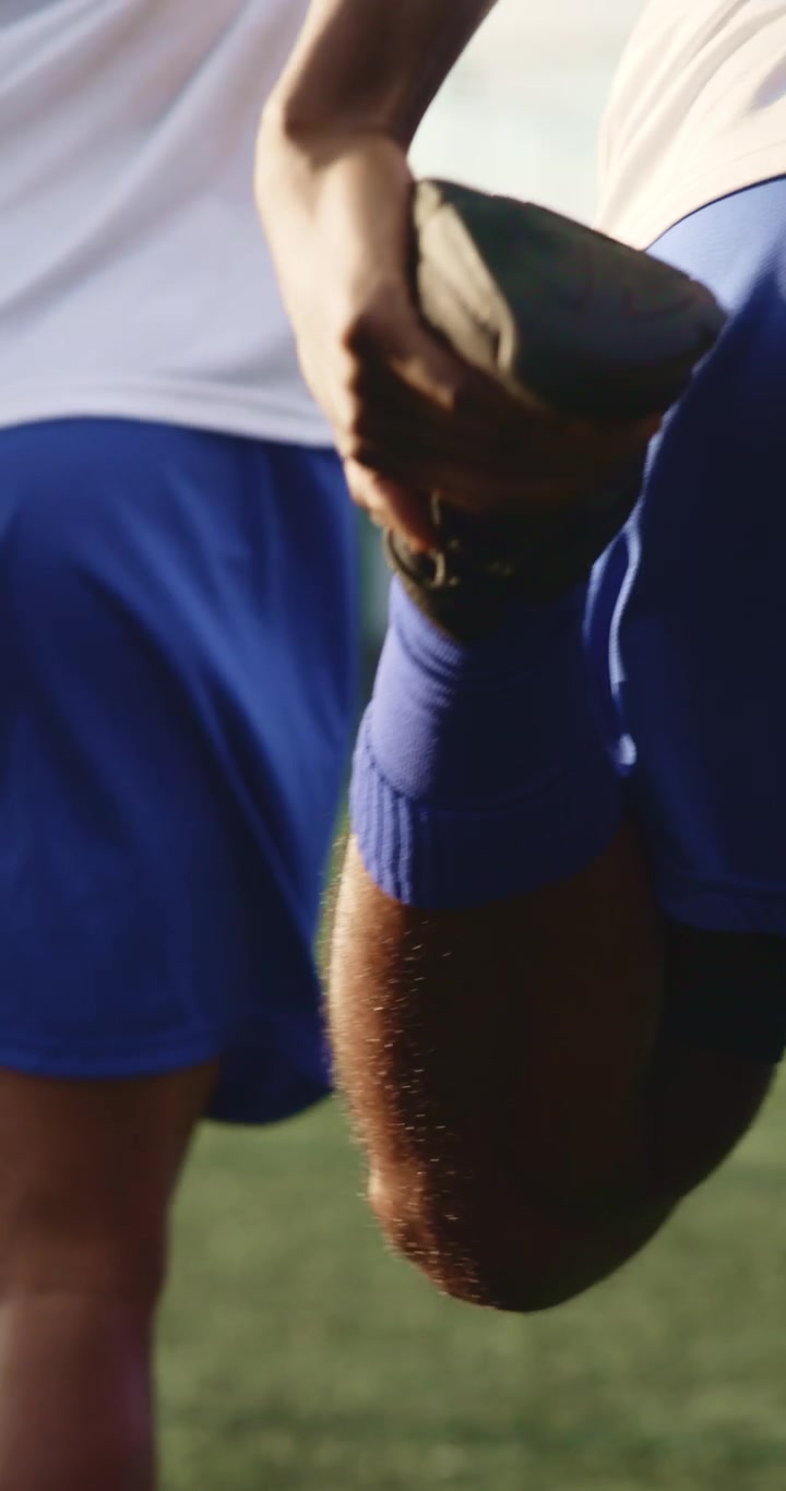 Giocatori di calcio che allungano le gambe in campo prima dell'allenamento