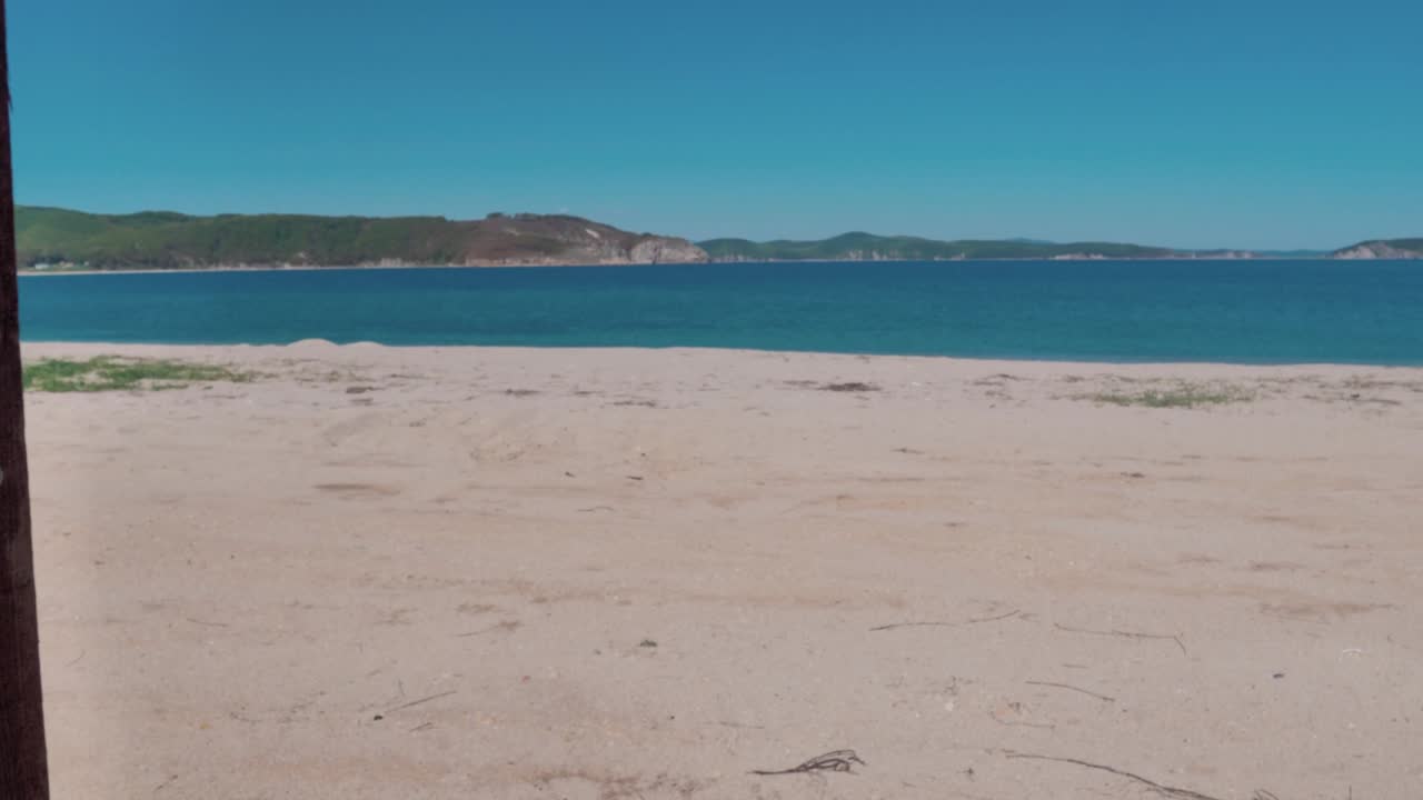 사람의 손으로 만든 나무 문이 터키즈색 바다와 함께 놀라운 열대 해변으로 문을 열고 완벽한 장소로 들어갑니다.