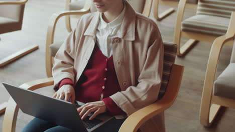 Woman-Typing-on-Laptop-in-Auditorium