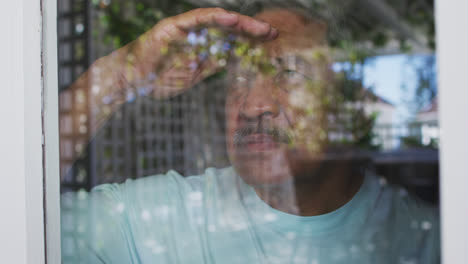 senior mixed race man sitting on bed looking away