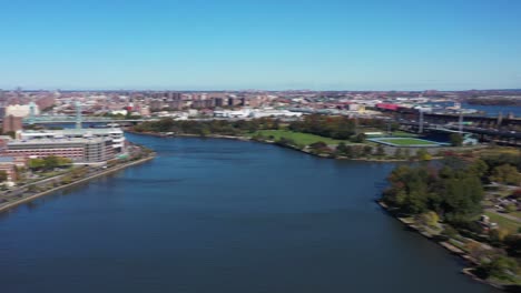 Fast-drone-pan-of-Harlem-River-between-Harlem,-Manhattan,-and-Randalls-and-Wards-Islands,-NYC