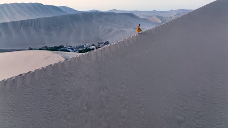mujer caminando por una duna de arena