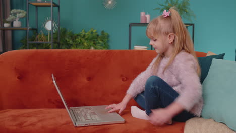 little school kid girl use laptop computer learning reading online education lessons alone at home