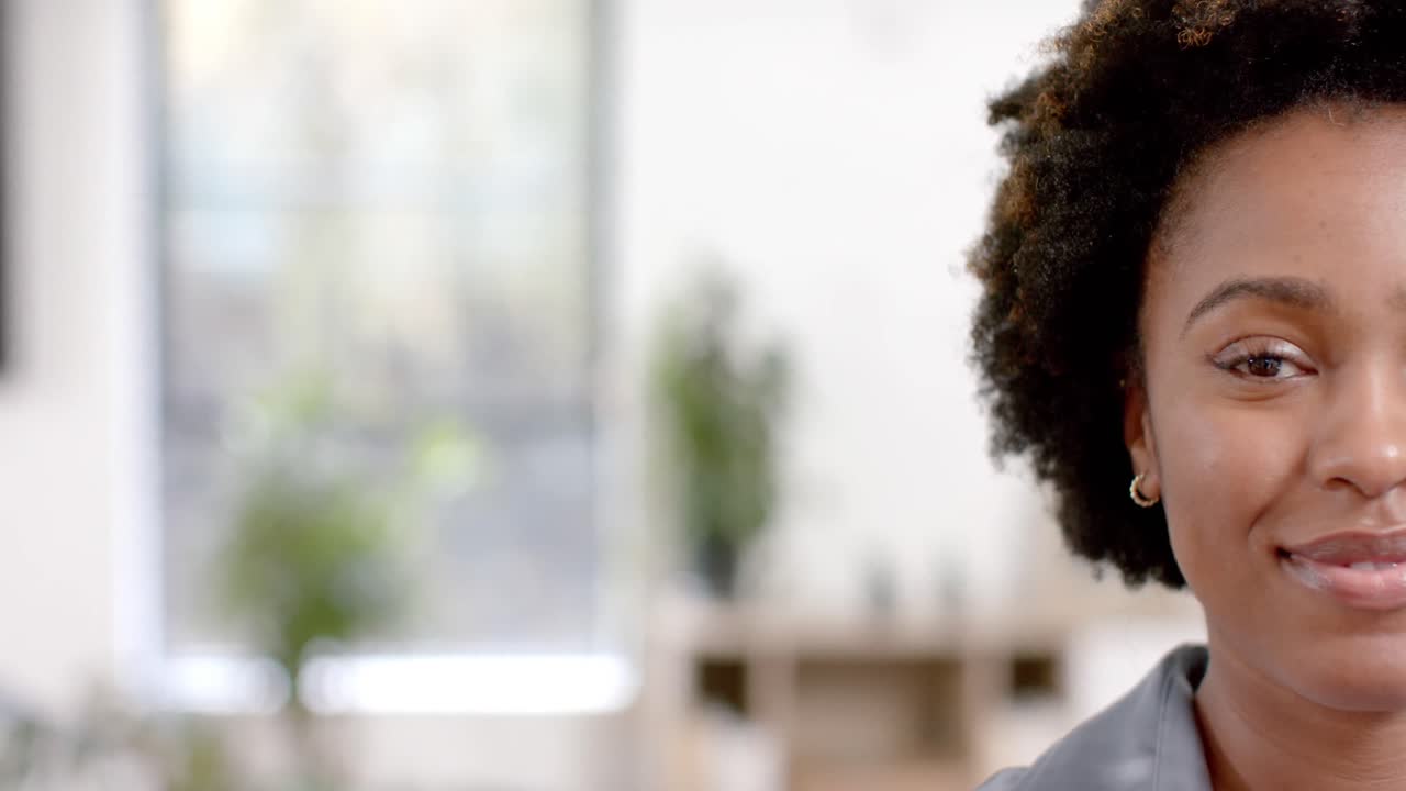 medio retrato de una feliz mujer de negocios afroamericana en la oficina con espacio de copia, cámara lenta