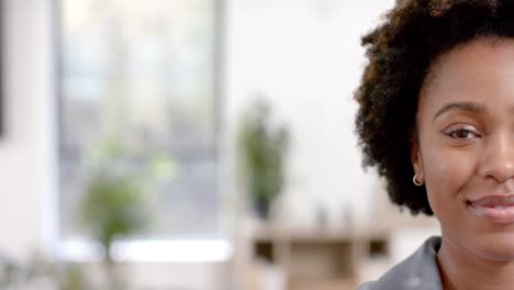 half portrait of happy african american casual businesswoman in office with copy space, slow motion