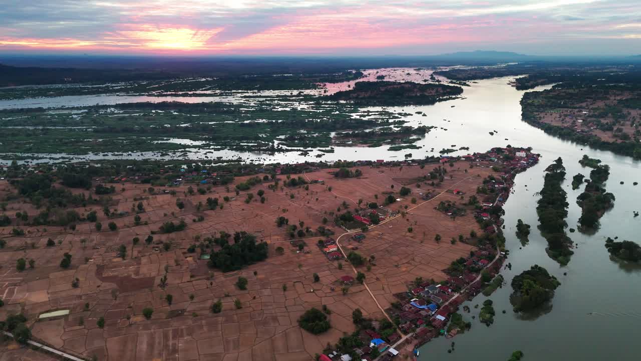 Aerial drone establishing fly Don Det, Village in Laos, sunset skyline above flooded islands