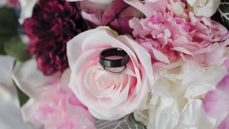 rings posed beautifully on a rose wedding bouquet