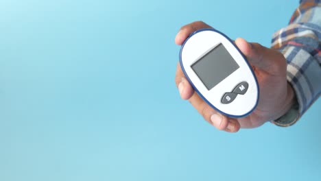 hand holding a blood glucose meter