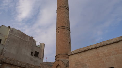 beautiful yellow stone minaret of abdullatif mosque from bottom up in mardin old town