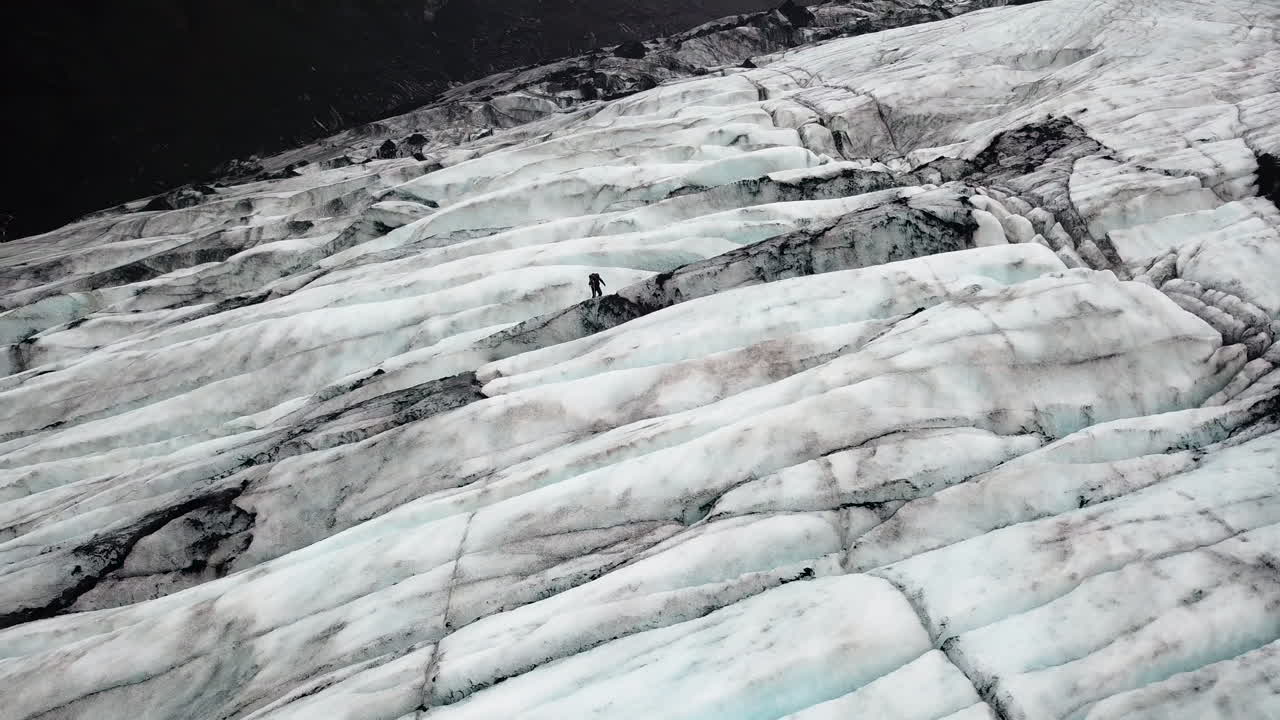 Aerial view of an extreme hiker on a large ice glacier