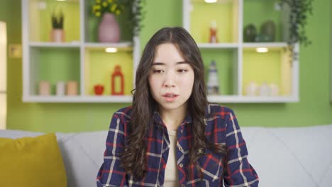 asian young woman looking at camera in horror.