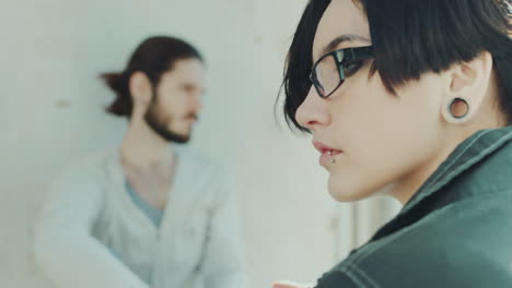 Portrait-Of-A-Young-Woman-In-Profile-Hipster-In-The-Background-Is-Her-Boyfriend-Concept---Relationsh