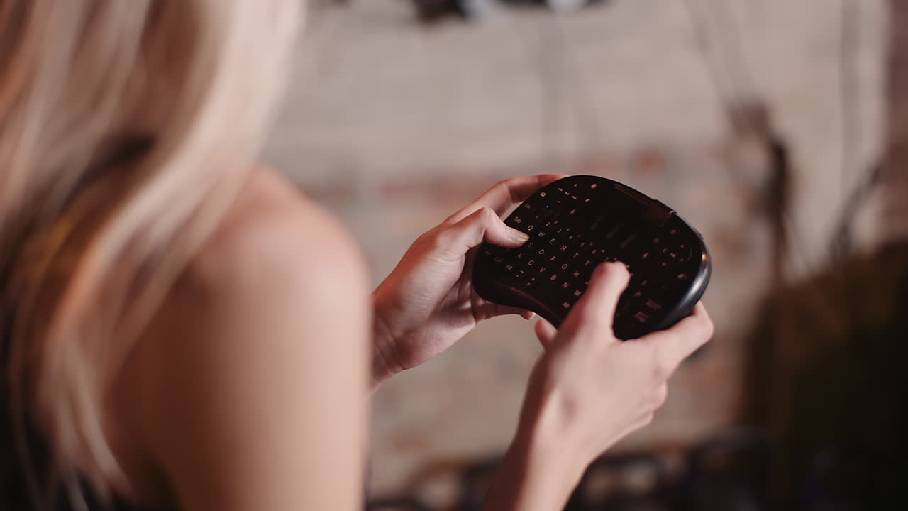 피트니스 스튜디오 1에서 무선 미니 키보드를 사용하는 여성 운동선수의 중앙부