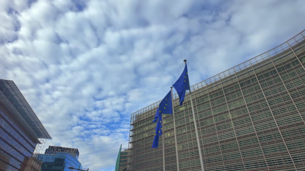 European Union flags fluttering under a dramatic sky in central Brussels