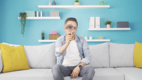 Man-looking-at-camera-with-magnifying-glass.