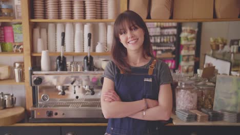 smiling small business owner standing arms crossed in coffee store