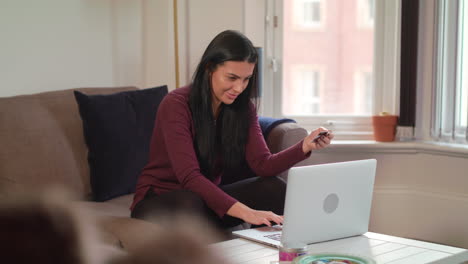 Young-Attractive-Woman-Enters-Credit-Card-Details-Into-Laptop-To-Make-Online-Purchase-And-Celebrates-When-Finished-With-Fist-Pump