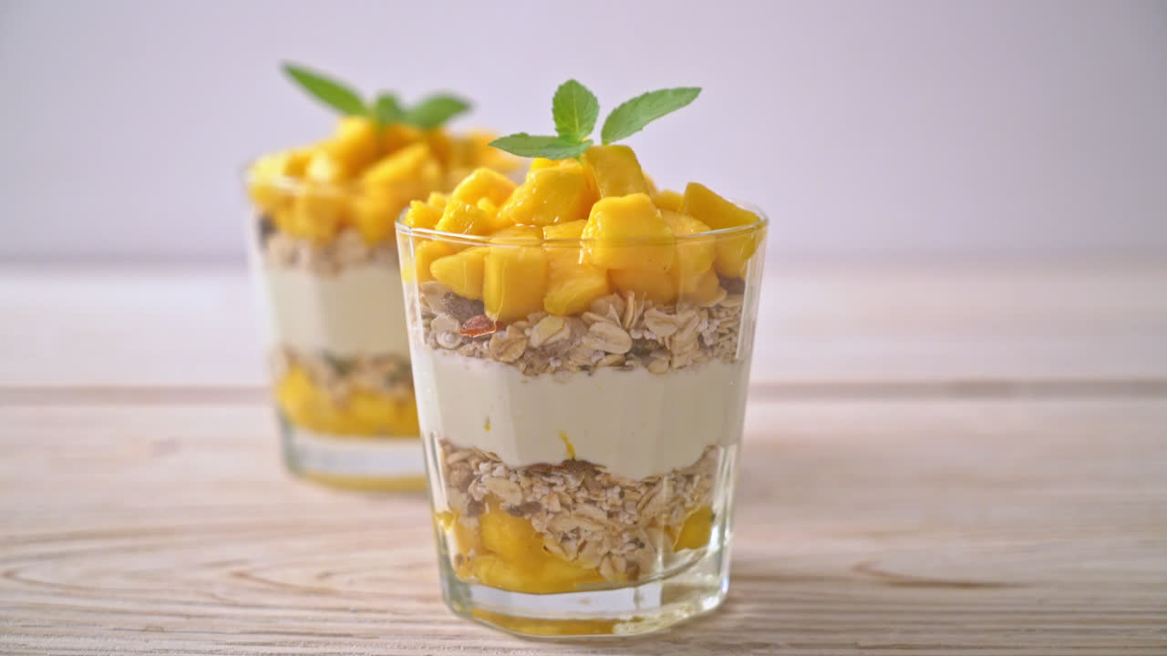 yogur de mango fresco con granola en vidrio - estilo de comida saludable