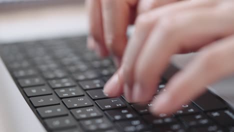 fotografía de cerca de las manos de una mujer de negocios escribiendo en el teclado de una computadora portátil para buscar información, soporte de comunicación en línea, investigación de mercadotecnia, informe de negocios en el escritorio de la oficina por la noche.