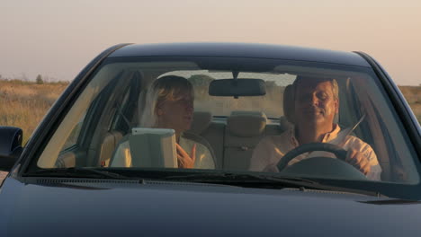 una pareja de ancianos viajando en coche por el campo